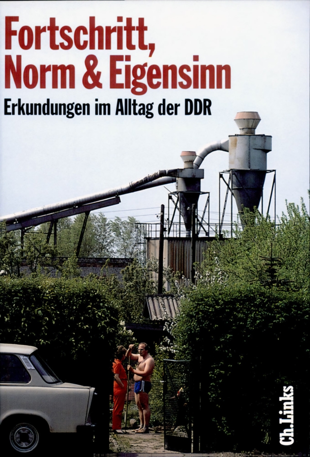 Großformatige rote Hauptüberschrift 'Fortschritt, Norm & Eigensinn' im oberen Drittel des Bildes, darunter in schwarzer kleinerer Schrift der Untertitel 'Erkundungen im Alltag der DDR'. Das darunter liegende Hauptfoto zeigt eine Industrieanlage mit zwei hohen Filtersilos und Rohrleitungen im Hintergrund. Im Vordergrund stehen ein Trabant und zwei Personen - eine in Arbeitskleidung, eine in Badehose. Die Szene ist von Grünflächen umrahmt. Am unteren rechten Bildrand befindet sich das Verlagslogo 'Ch.Links'