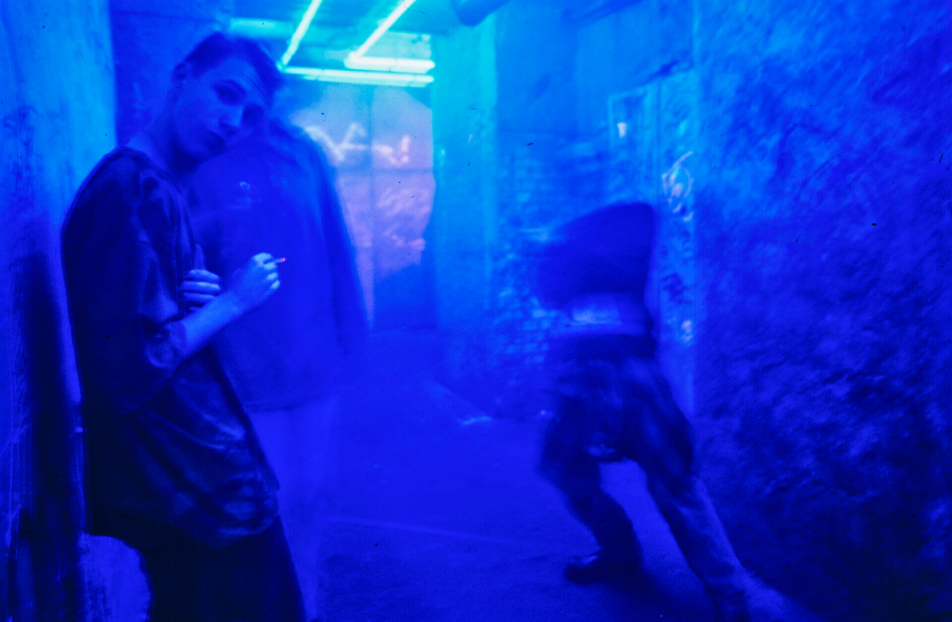Ein junger Mann steht rauchend im Berliner Technoclub Tresor und schaut in die Kamera.
